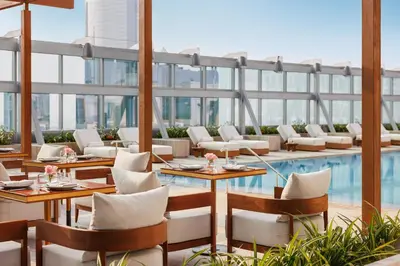 a restaurant with a pool and tables and chairs at Jumeirah Living World Trade Centre Dubai in Dubai