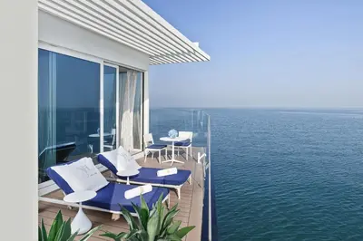 a balcony with chairs and a view of the water at Jumeirah Burj Al Arab Dubai in Dubai