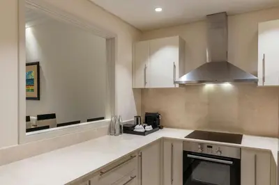 a kitchen with white cabinets and a window at Grosvenor House, a Luxury Collection Hotel, Dubai in Dubai