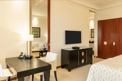 a hotel room with a bed and a desk and a television at Grosvenor House, a Luxury Collection Hotel, Dubai in Dubai