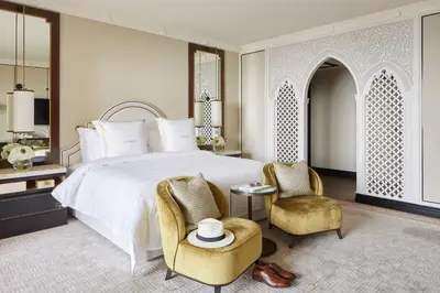 a bedroom with a large bed and two chairs at Jumeirah Mina Al Salam Dubai in Dubai