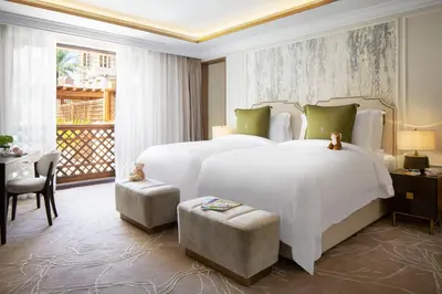 a bedroom with a large white bed and a balcony at Jumeirah Dar Al Masyaf Dubai in Dubai