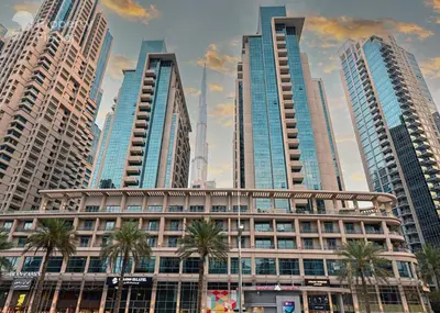 a building with palm trees in front of tall buildings at Dream Inn Apartments- Boulevard Heights in Dubai