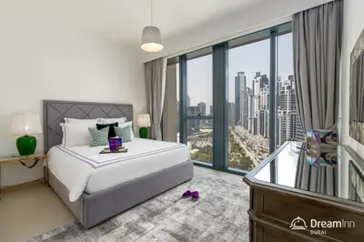 a bedroom with a bed with a view of a city at Dream Inn Apartments- Boulevard Heights in Dubai
