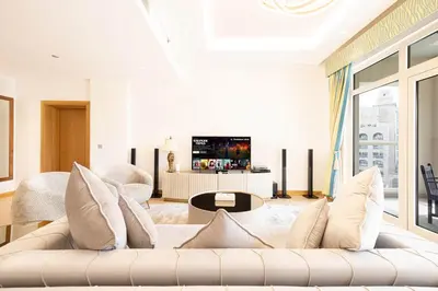 a living room with a couch and a tv at Royal Club By RVHR, Palm Jumeirah in Dubai