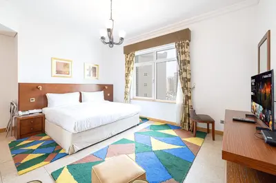 a bedroom with a bed and a desk and a television at Royal Club By RVHR, Palm Jumeirah in Dubai
