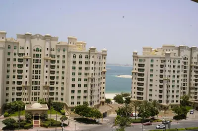 a group of tall buildings with the ocean in the background at Royal Club By RVHR, Palm Jumeirah in Dubai