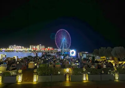 a crowd of people at a fair with a ferris wheel at Ramada Hotel, Suites and Apartments by Wyndham Dubai JBR in Dubai
