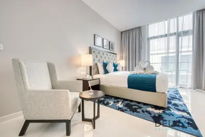 a bedroom with a king sized bed and a chair at Calm Studio in Damac Celestia A Dubai South by Deluxe Holiday Homes in Dubai