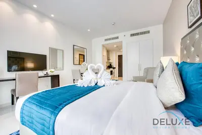 a bedroom with a large white bed with blue sheets at Calm Studio in Damac Celestia A Dubai South by Deluxe Holiday Homes in Dubai