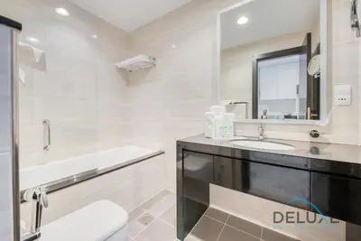 a bathroom with a tub and a sink and a mirror at Calm Studio in Damac Celestia A Dubai South by Deluxe Holiday Homes in Dubai
