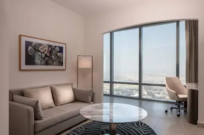 a living room with a couch and a glass table at The First Collection Dubai Jumeirah Village Circle, a Tribute Portfolio Hotel in Dubai