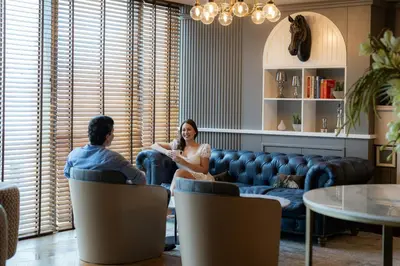 a man and a woman sitting in a waiting room at The First Collection Dubai Jumeirah Village Circle, a Tribute Portfolio Hotel in Dubai