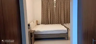 a small bed in a room with a window at Furnished Studio Apartments for rent in Dubai in Dubai