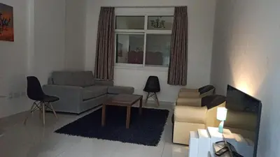 a living room with a couch and a tv in it at Furnished Studio Apartments for rent in Dubai in Dubai