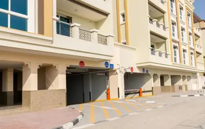 an empty parking lot in front of a building at Cozy Rooms and Small Partitions for Men guests in Dubai in Dubai
