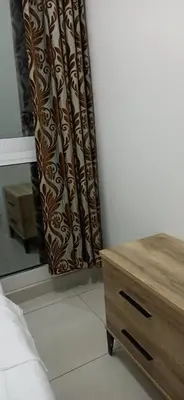 a bedroom with a bed and a dresser and a curtain at Cozy Rooms and Small Partitions for Men guests in Dubai in Dubai