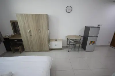 a room with a bed and a desk and a refrigerator at Cozy Rooms and Small Partitions for Men guests in Dubai in Dubai