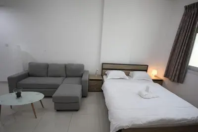 a small bedroom with a bed and a couch at Cozy Rooms and Small Partitions for Men guests in Dubai in Dubai