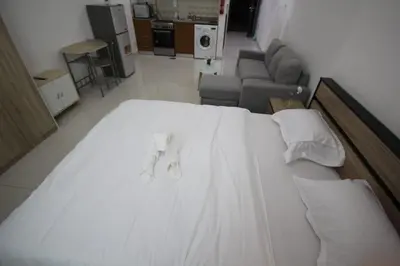 a large white bed in a room with a couch at Cozy Rooms and Small Partitions for Men guests in Dubai in Dubai