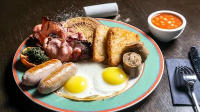 a plate of breakfast food with eggs sausage and toast at Hilton Dubai Jumeirah in Dubai