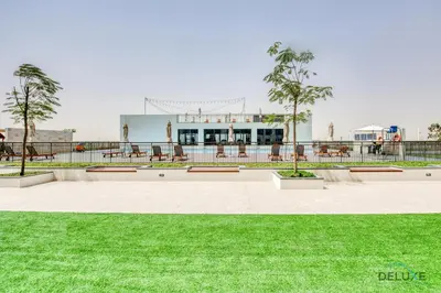a park with green grass and a building at Charismatic 1BR at UNA Town Square Dubailand by Deluxe Holiday Homes in Dubai