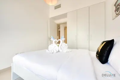 two stuffed rabbits sitting on top of a white bed at Charismatic 1BR at UNA Town Square Dubailand by Deluxe Holiday Homes in Dubai