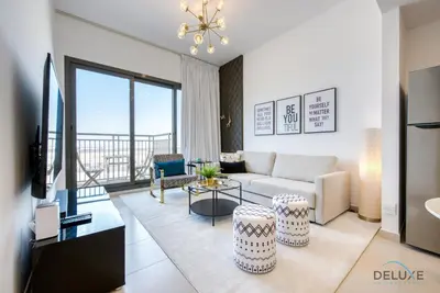 a living room with a couch and a tv at Charismatic 1BR at UNA Town Square Dubailand by Deluxe Holiday Homes in Dubai