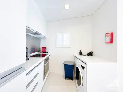 a white kitchen with a sink and a washing machine at Dubai Mall 1Bedroom Balcony in Dubai