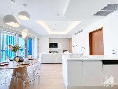 a kitchen with white cabinets and a table and chairs at Dubai Mall 1Bedroom Balcony in Dubai