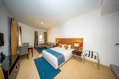 a bedroom with a large bed and a living room at City Stay Grand Hotel Apartments - Al Barsha in Dubai