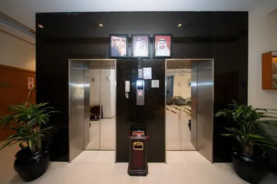 a lobby with a elevator with people on the wall at City Stay Grand Hotel Apartments - Al Barsha in Dubai