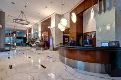 two men sitting at a bar in a hotel lobby at Rose Rayhaan by Rotana - Dubai in Dubai