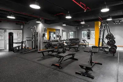 a gym with several treadmills and machines in a room at Rose Rayhaan by Rotana - Dubai in Dubai