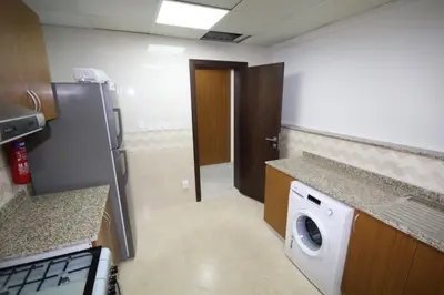 a small kitchen with a washer and dryer in it at Budget Rental Studio Apartments in Dubai in Dubai