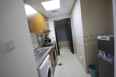 a small kitchen with a sink and a microwave at Budget Rental Studio Apartments in Dubai in Dubai