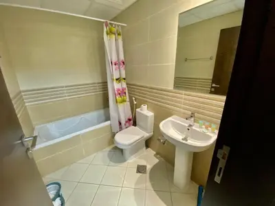 a bathroom with a sink and a toilet and a mirror at Budget Rental Studio Apartments in Dubai in Dubai