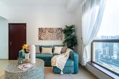 a living room with a blue couch and a table at The Smart Concierge - Bahar 6 in Dubai
