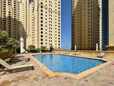 a large swimming pool in a city with tall buildings at The Smart Concierge - Bahar 6 in Dubai