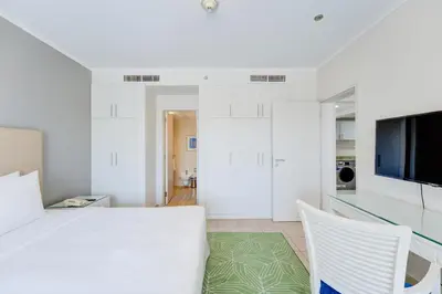 a white room with a table and two chairs at Millennium Lakeview Residences in Dubai