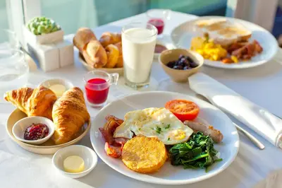 a table with plates of breakfast food on it at Millennium Lakeview Residences in Dubai