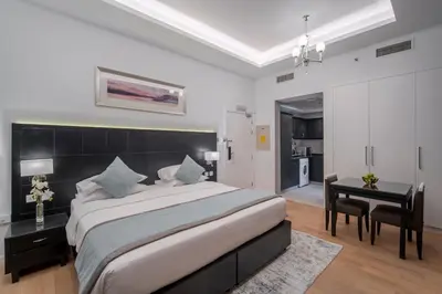 a bedroom with a large bed and a desk at Rose Garden Hotel Apartments - Al Barsha, Near Metro Station in Dubai