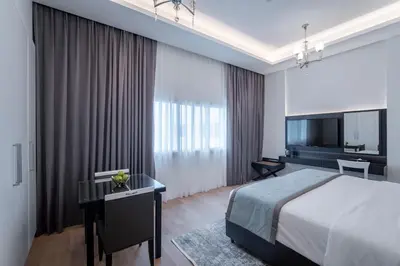 a bedroom with a bed and a desk and a television at Rose Garden Hotel Apartments - Al Barsha, Near Metro Station in Dubai