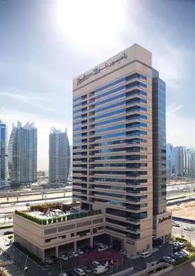a tall building with a sign on the side of it at Radisson Blu Residence, Dubai Marina in Dubai
