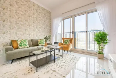 a living room with a couch and a table at Sunny 1BR at Canal Residences West Dubai Sports City by Deluxe Holiday Homes in Dubai