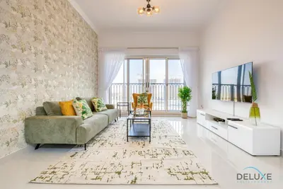 a living room with a couch and a tv at Sunny 1BR at Canal Residences West Dubai Sports City by Deluxe Holiday Homes in Dubai