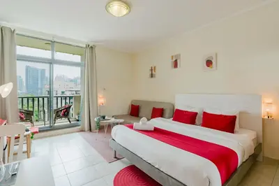 a bedroom with a large bed and a balcony at RH - Beautiful canal view, Sleek & spacious Studio, central location in Dubai
