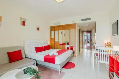a bedroom with a bed and a couch and a table at RH - Beautiful canal view, Sleek & spacious Studio, central location in Dubai