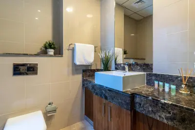 a bathroom with a sink and a large mirror at The Smart Concierge - Bay Central in Dubai