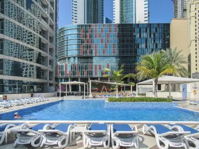 a swimming pool with lounge chairs and buildings at The Smart Concierge - Bay Central in Dubai